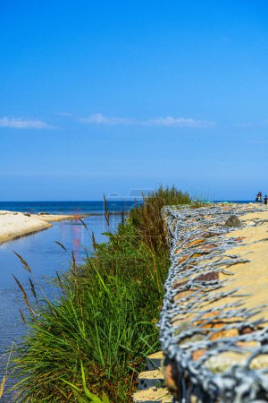 Photo for The mouth of the Czarna Woda river into the Baltic Sea and view on a sandy beach, Karwia, Poland - Royalty Free Image