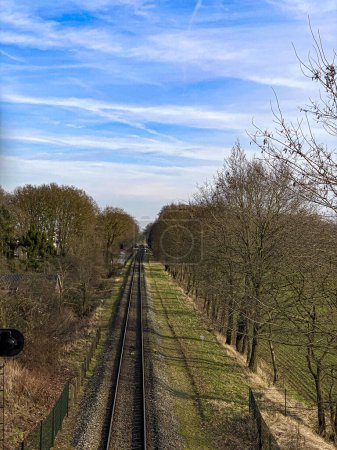 Railway tracks in the countryside in springtime with a blue sky