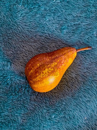 Bodegón otoñal con peras sobre fondo azul.