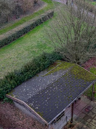 Aerial view of an old house with a roof covered with moss