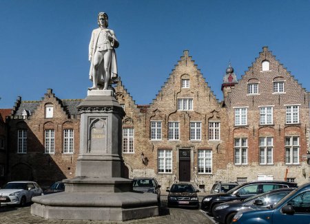 Téléchargez les photos : Bruges, Belgique - 15 mars 2012 : Sur la place "woensdagmarkt" se dresse une statue du peintre du XVe siècle Hans Memling, qui a passé la dernière partie de sa vie dans la ville. Il a été fabriqué par Hendrik Pickery et placé là en 1871. - en image libre de droit