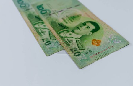 Deux billets thaïlandais d'une valeur de 20 bahts, isolés sur fond blanc.