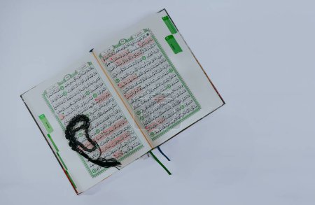 Photo for Surabaya, Indonesia, Jan 28, 2024 - Quran,Koran,Al Quran, Islamic background for Eid Al Fitr Eid Al Adha. Open page with prayer beads, selective focus. Madinah manuscript on white background. Top view. - Royalty Free Image