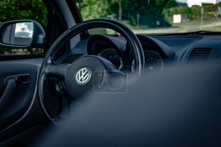 Photo for German engineering: A german car brand interior with fokus on the massive leather steering wheel in the middle is the VW emblem - Royalty Free Image