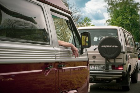 Foto de Explore el encanto vintage de los automóviles alemanes en el T3 Caravan Show 2023 de Hannover. 2 furgonetas detrás de la otra, el conductor sostiene es la mano por la ventana - Imagen libre de derechos