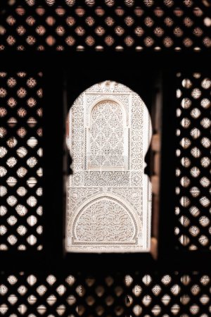 Téléchargez les photos : Détail des décorations de la Madrasa Bou Inania vues à travers un treillis en bois d'un dortoir, Meknès, Maroc - en image libre de droit
