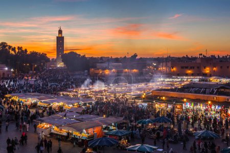 Foto de MARRAKESH, MARRUECO- 28 DE DICIEMBRE DE 2014: Multitud en la plaza Jemaa el Fna al atardecer del 28 de diciembre de 2014 en Marrakech, Marruecos - Imagen libre de derechos
