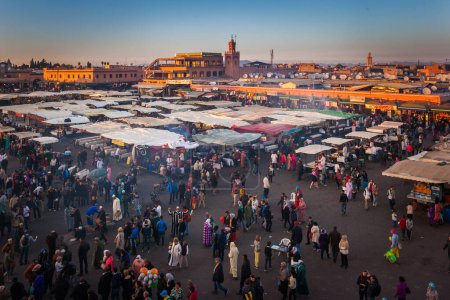 Foto de MARRAKESH, MARRUECO- 28 DE DICIEMBRE DE 2014: Multitud en la plaza Jemaa el Fna al atardecer del 28 de diciembre de 2014 en Marrakech, Marruecos - Imagen libre de derechos