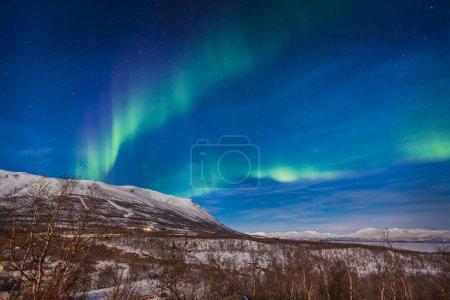 Photo for Display of aurora borealis in full moon light, Abisko, Sweden - Royalty Free Image