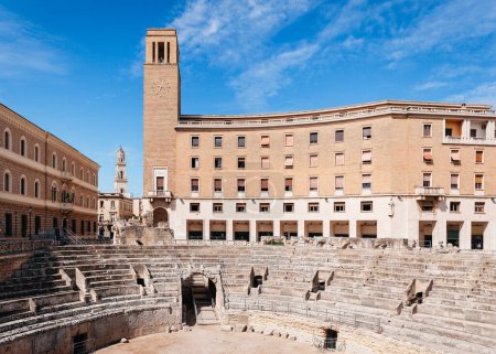 Foto de Vista de la plaza de San Oronzo en Lecce, Italia con el Anfiteatro Romano y la campana de la torre de la Iglesia Catedral en la distancia. - Imagen libre de derechos