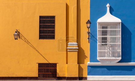 Foto de Arquitectura de estilo tradicional con pared azul y amarilla y delicadas barandillas de ventanas, Trujillo, Perú - Imagen libre de derechos