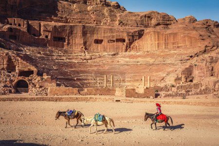 Foto de El Teatro Romano en Petra, Jordania, con burros y un beduino montando su burro - Imagen libre de derechos