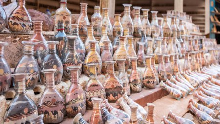 Foto de Botellas de recuerdo de colores con arena y formas de desierto y camellos, Petra, Jordania. - Imagen libre de derechos