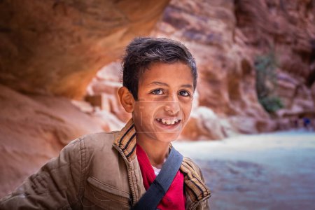 Foto de Potrait de un niño beduino sonriente, vendedor de postales, Petra, Jordania - Imagen libre de derechos