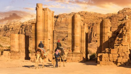 Foto de Camellos transportando turistas frente a la Puerta de Temenos, Petra Jordania - Imagen libre de derechos