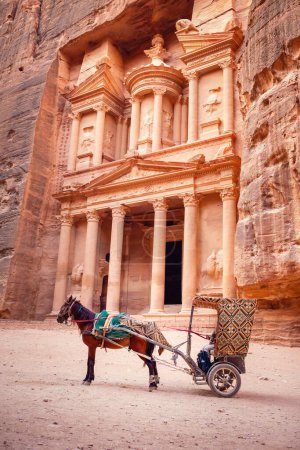 Foto de El templo del Tesoro (Al Khazneh) y un carro de caballos utilizado para el transporte turístico, Petra Jordania - Imagen libre de derechos