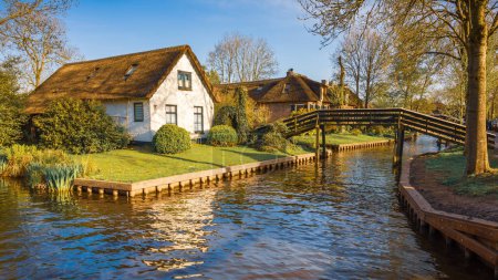 Foto de Precioso paisaje con canal, pasarelas de madera y casas holandesas al atardecer, Giethoorn, Países Bajos - Imagen libre de derechos