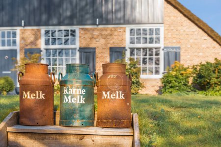 Alte Fässer für Milch und Molke vor einem großen niederländischen Haus, Giethoorn, Niederlande