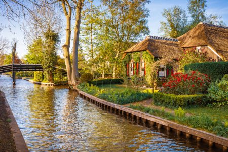 Foto de Precioso paisaje con canal y pintorescas casas con persianas rojas, Giethoorn, Países Bajos - Imagen libre de derechos