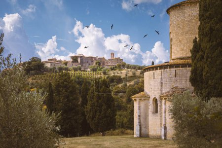 Foto de El ábside de la Abadía de Sant 'Antimo con el pueblo de Castelnuovo dell' Abate de fondo, Montalcino, Toscana, Italia - Imagen libre de derechos