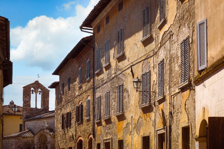 Téléchargez les photos : Bâtiments médiévaux dans la rue principale avec l'église de Santa Maria Assunta, San Quirico d'Orcia, Italie - en image libre de droit