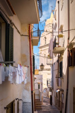 Photo for A picturesque alley in Vieste with view on the bell tower of the Cathedral of Santa Maria Assunta, Puglia, Italy - Royalty Free Image
