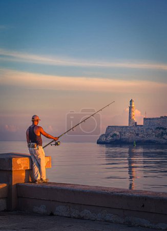 Foto de Hombre cubano pescando frente a la famosa fortaleza de El Morro, La Habana, Cuba - Imagen libre de derechos