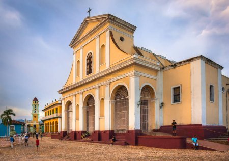 Foto de Plaza Mayor y la Iglesia de la Santísima Trinidad después del atardecer cuando la gente local y los turistas salen y pasean sobre adoquines, Trinidad, Cuba - Imagen libre de derechos