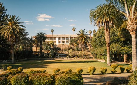 Foto de Vista del edificio del Parlamento y los jardines del Parlamento, Windhoek, Namibia. Nombrado también Palacio de tinta o Tintenpalast en honor de toda la tinta gastada en papeleo oficial típicamente excesivo. - Imagen libre de derechos