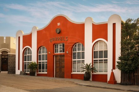 Foto de La encantadora fachada del famoso Barrels Pub en Luderitz, Namibia, que perdura la arquitectura de la época colonial alemana. - Imagen libre de derechos