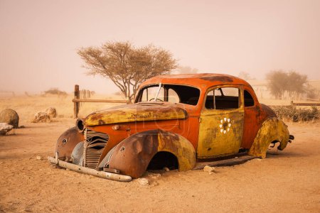 Foto de Coche abandonado en la estación de servicio de Solitaire en la región de Komas, Namibia. La estación, ubicada dentro del desierto de Namib, es una popular atracción turística conocida por su delicioso pastel de manzana.. - Imagen libre de derechos