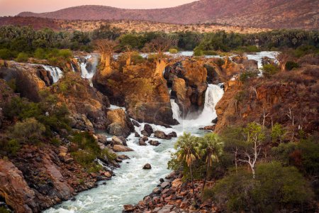 Chutes d'Epupa, région de Kunene, Namibie, dans une lumière chaude et dorée. Epupa Falls est une série de grandes chutes d'eau formées par la rivière Kunene à la frontière de l'Angola et de la Namibie.