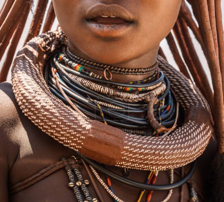 Foto de Joyería tradicional de mujeres Himba, al norte de Opuwo, Namibia. Está hecho a mano con materiales locales como cuero, cobre, cáscaras de avestruz, perlas y ropa. Los nuevos también están hechos con tubos de PVC! - Imagen libre de derechos