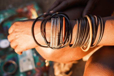 Himba Armbänder. Himba-Frauen tragen traditionell Armbänder aus lokalen Materialien wie Leder und Metall sowie moderne Materialien wie PVC-Rohre. Katutura, Windhoek, Namibia.