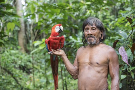 Foto de Hombres huaorani de la tribu Waorani posando con guacamayo rojo en las manos, región amazónica de Ecuador - Imagen libre de derechos