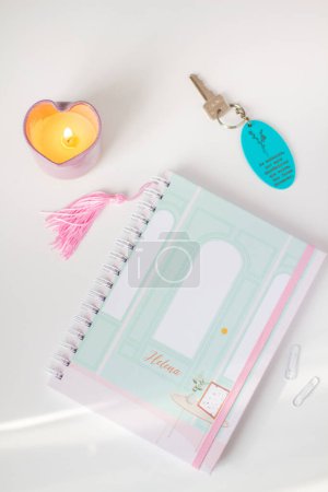 Photo for Feminine composition with notepad, keychain, paper clips and candle on white background. - Royalty Free Image