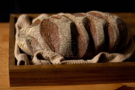 Foto de Primer plano de pan marrón decorado en la mesa de madera. Composición oscura. Concepto de panadería. - Imagen libre de derechos