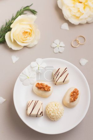 Foto de Caramelos gourmet en plato blanco. Composición de primavera sobre fondo gris. concepto de recepción de boda. - Imagen libre de derechos