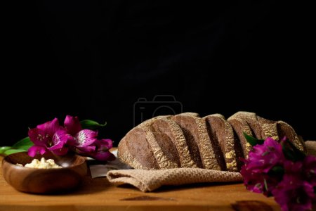 Foto de Primer plano de pan marrón decorado en la mesa de madera. Composición oscura. Concepto de panadería. - Imagen libre de derechos