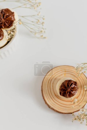 Téléchargez les photos : Délicieux bonbons gourmands au chocolat blanc décorés de fleurs séchées sur fond blanc. Stylisme alimentaire. - en image libre de droit