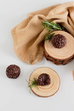 Photo for Traditional brazilian brigadeiro candies decorated with pine woods. Aesthetic composition. Food Styling. - Royalty Free Image