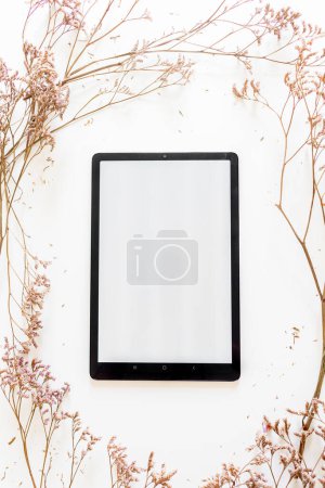 Foto de Vista superior de marco redondo de flores lila con tableta digital sobre fondo blanco - Imagen libre de derechos