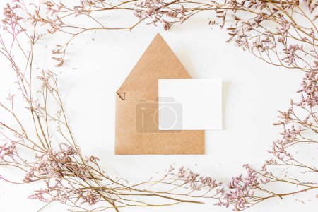 Photo for Floral frame made from lilac flowers and kraft paper envelope in the middle. - Royalty Free Image