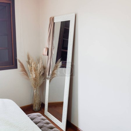 Foto de Diseño clásico moderno. Elegante dormitorio con espejo y ramo de flores secas. - Imagen libre de derechos