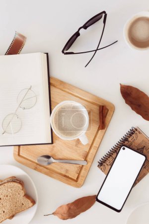 Foto de Otoño Composición del desayuno con libro, anteojos y hojas secas alrededor. - Imagen libre de derechos