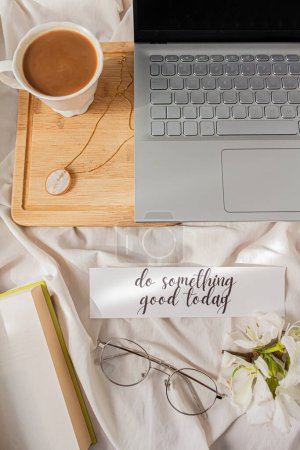 Photo for Inspirational quote: "do something good today". Modern home office desk with laptop, book, tea latte cup on messy background. Flat lay, top view. Autumn, fall concept. - Royalty Free Image