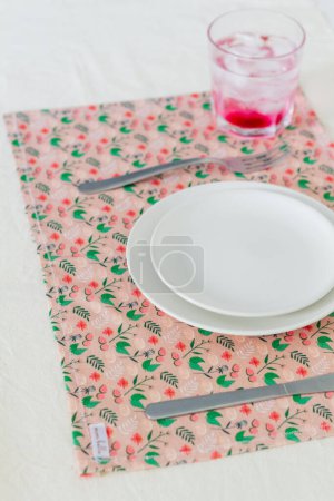 Photo for Gooseberry drink with ice cubes in glass and served empty kitchenware on colorful tablecloth - Royalty Free Image