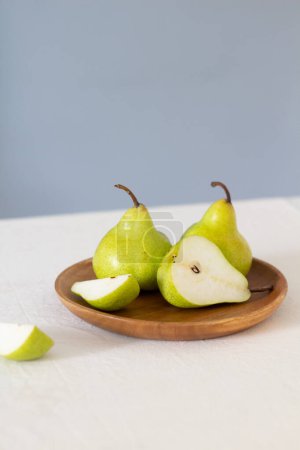 Foto de Peras verdes en un plato de madera - Imagen libre de derechos