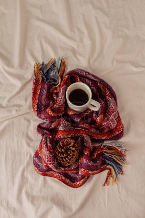 Photo for Autumn, fall composition. A cup of coffee, chilean warm scarf and a pine on a beige linen bed. Lifestyle, slow morning, seasonal fashion concept. - Royalty Free Image