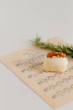 Photo for Food styling concept, white chocolate candy decorated with walnut kernel and rosemary stem - Royalty Free Image